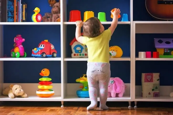 niño explorando estante de juguetes
